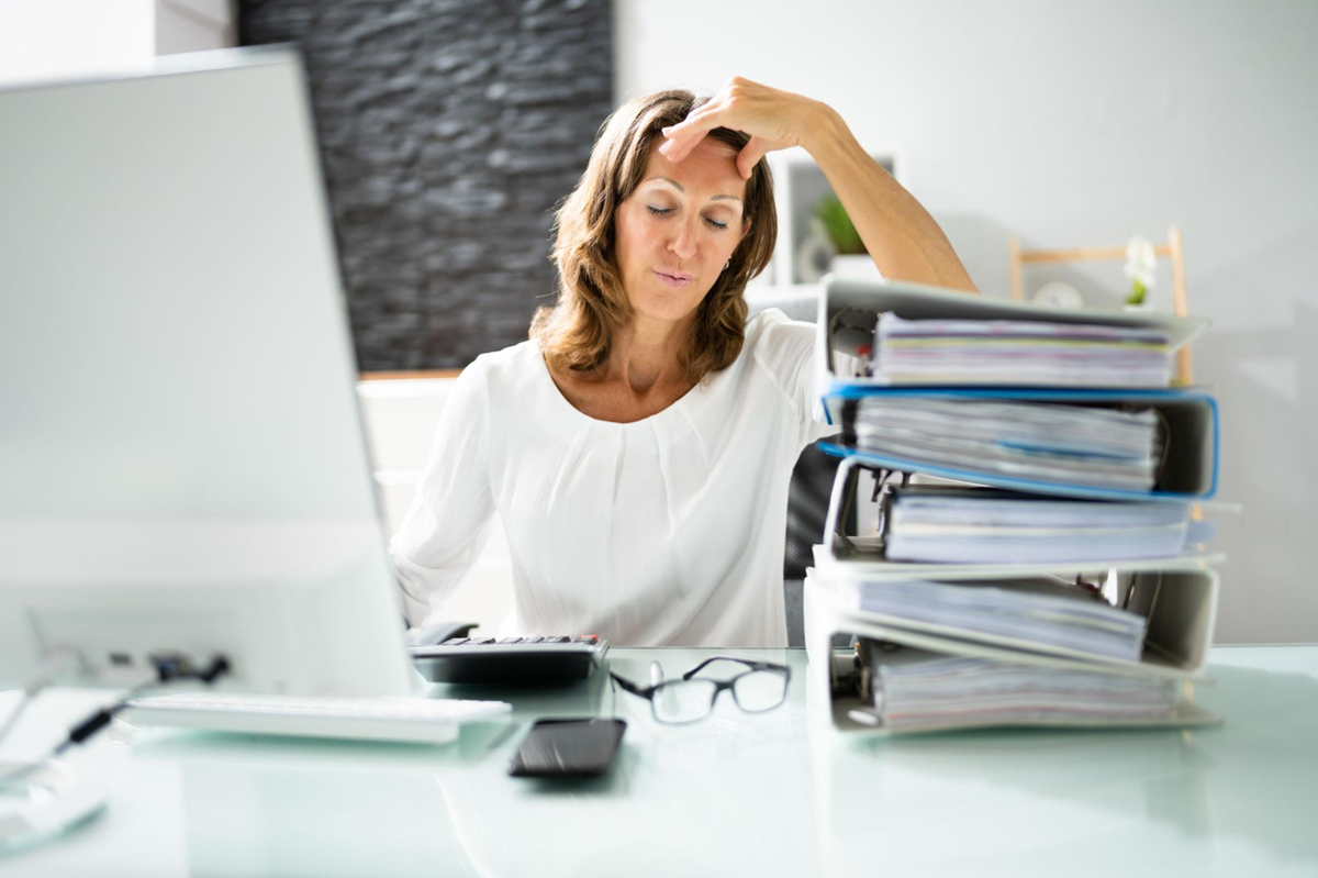 Woman feeling stressed in front of laptop